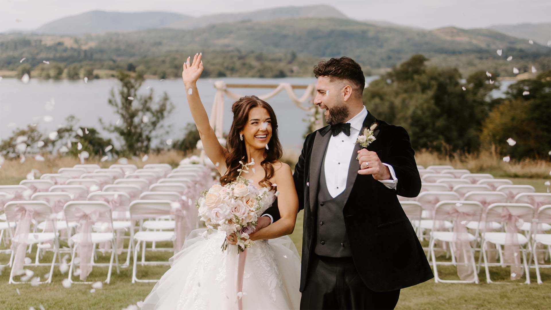 Newly weds celebrating on the infinity platform on the hillside above Low wood Bay