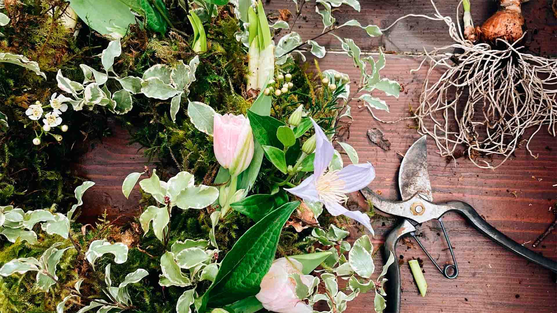 A woman making a wreath with flowers and foliage