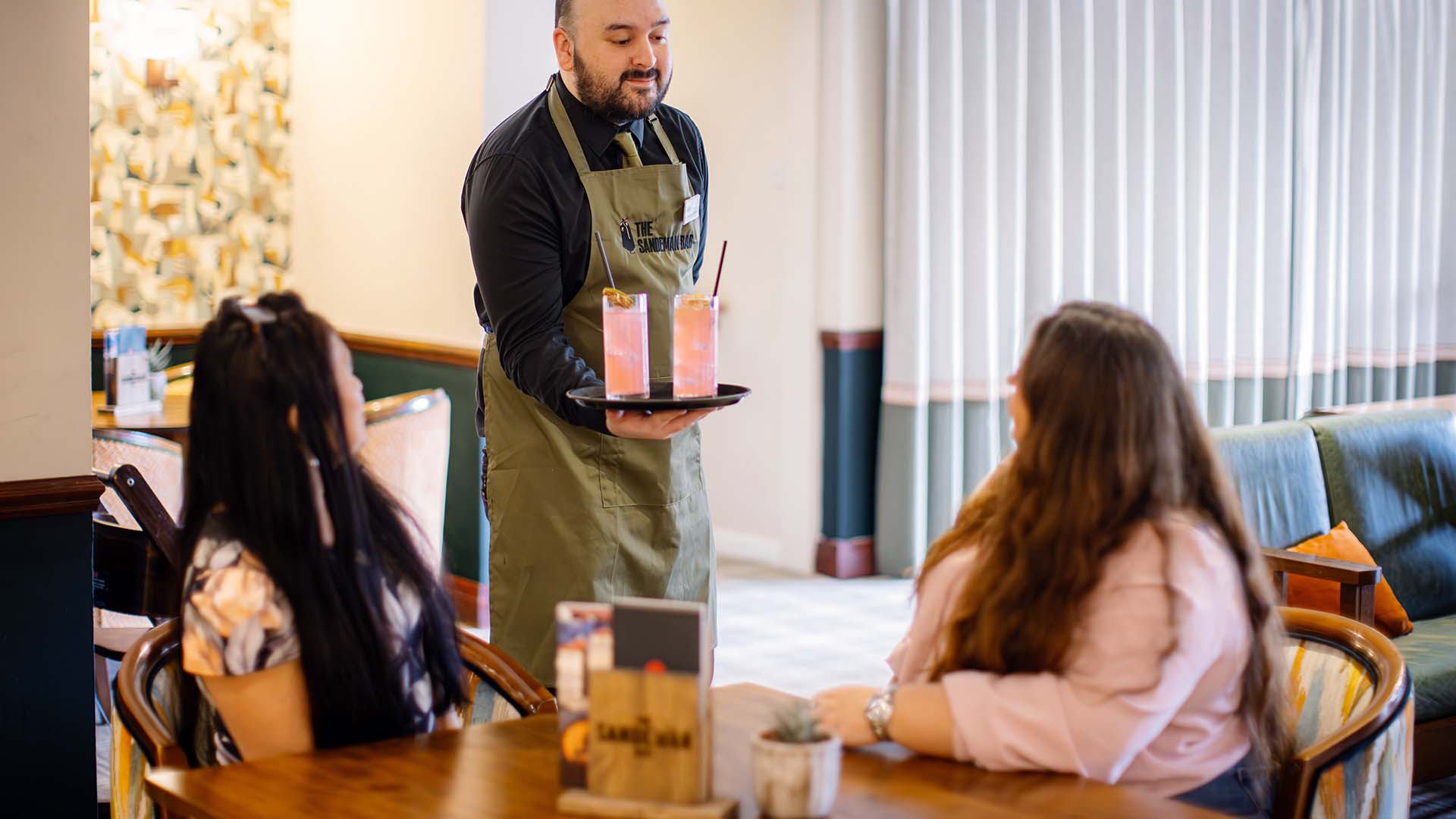 Waiter serving two customers in the Sandeman Bar