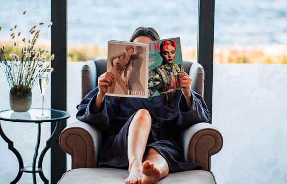 Young woman reading Vogue magazine