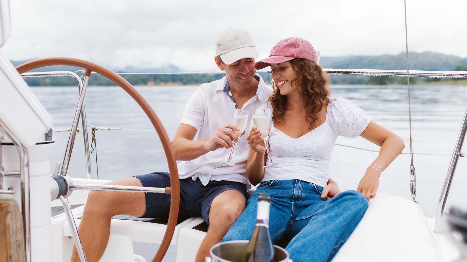 couple sat aboard a charter yacht enjoying a glass of champagne