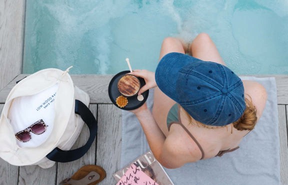 Young woman sat by the poolside