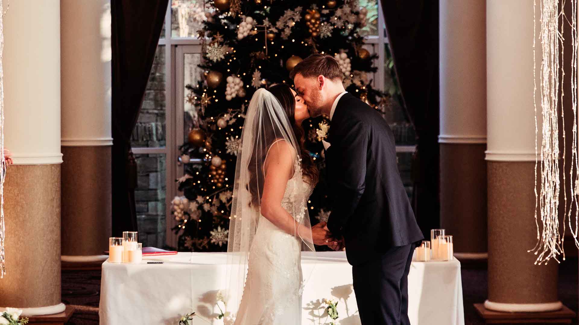 Newly weds kiss infront of the Christmas Tree in the Gallery Lounge