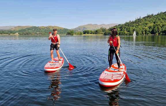 Couple stand up paddle boarding on Windermere