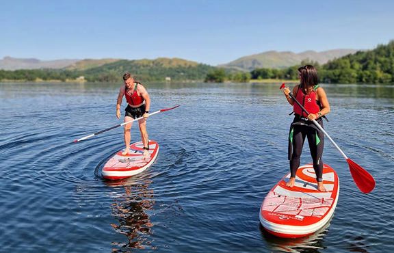 Couple stand up paddle boarding on Windermere