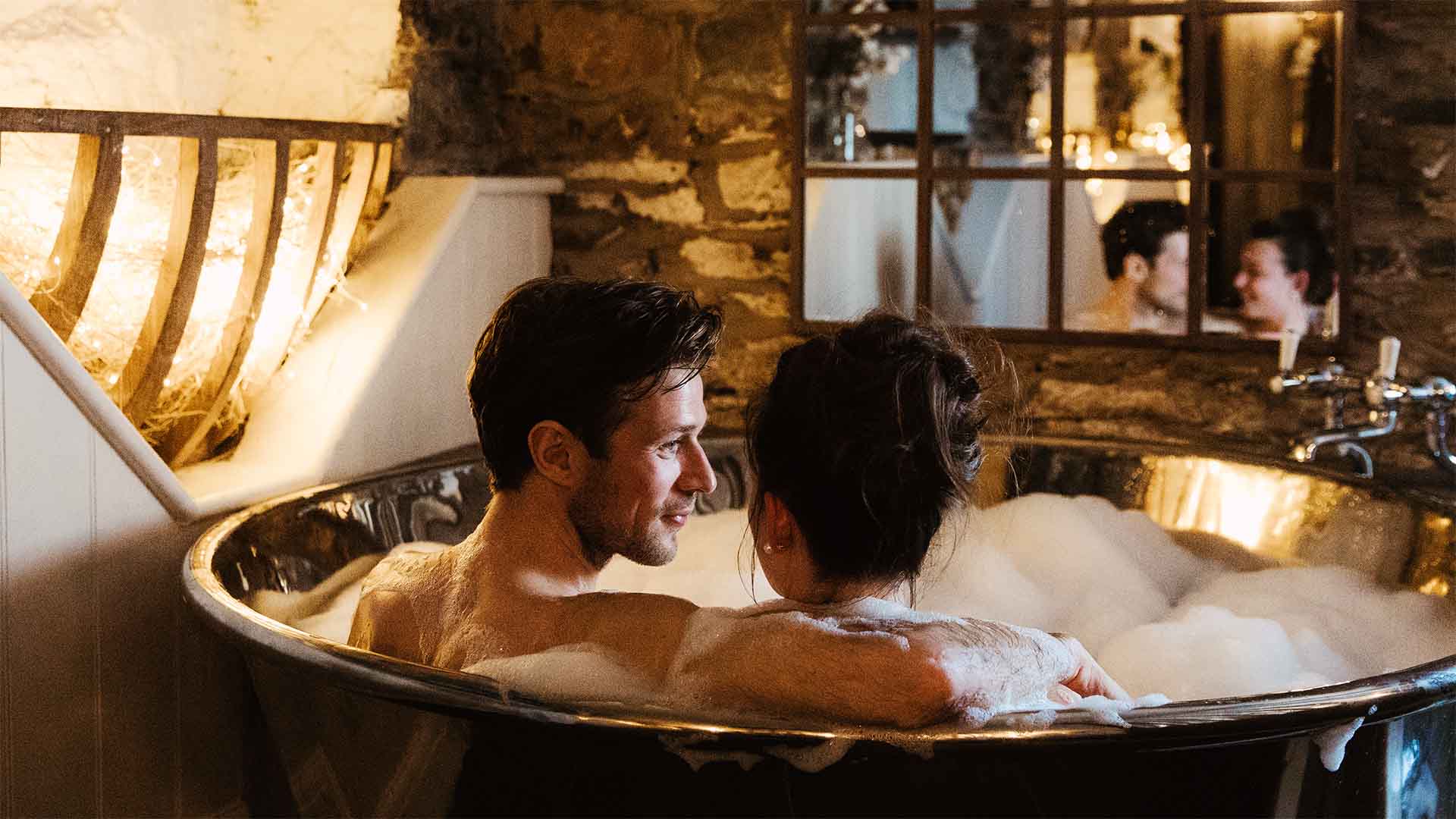 Couple sat in the bath in the hideaway treatment room