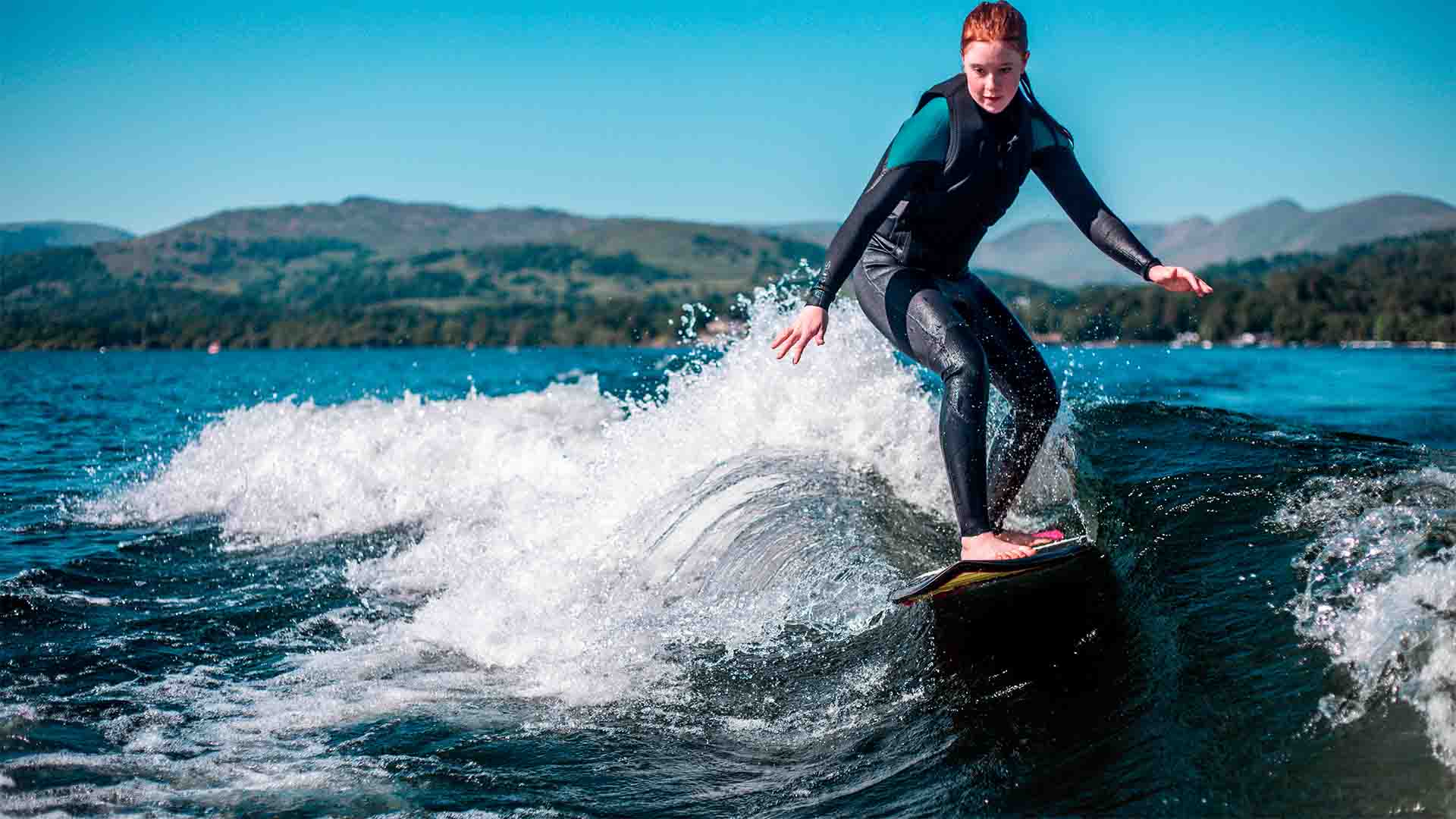 Young woman wakesurfing on lake Windermere