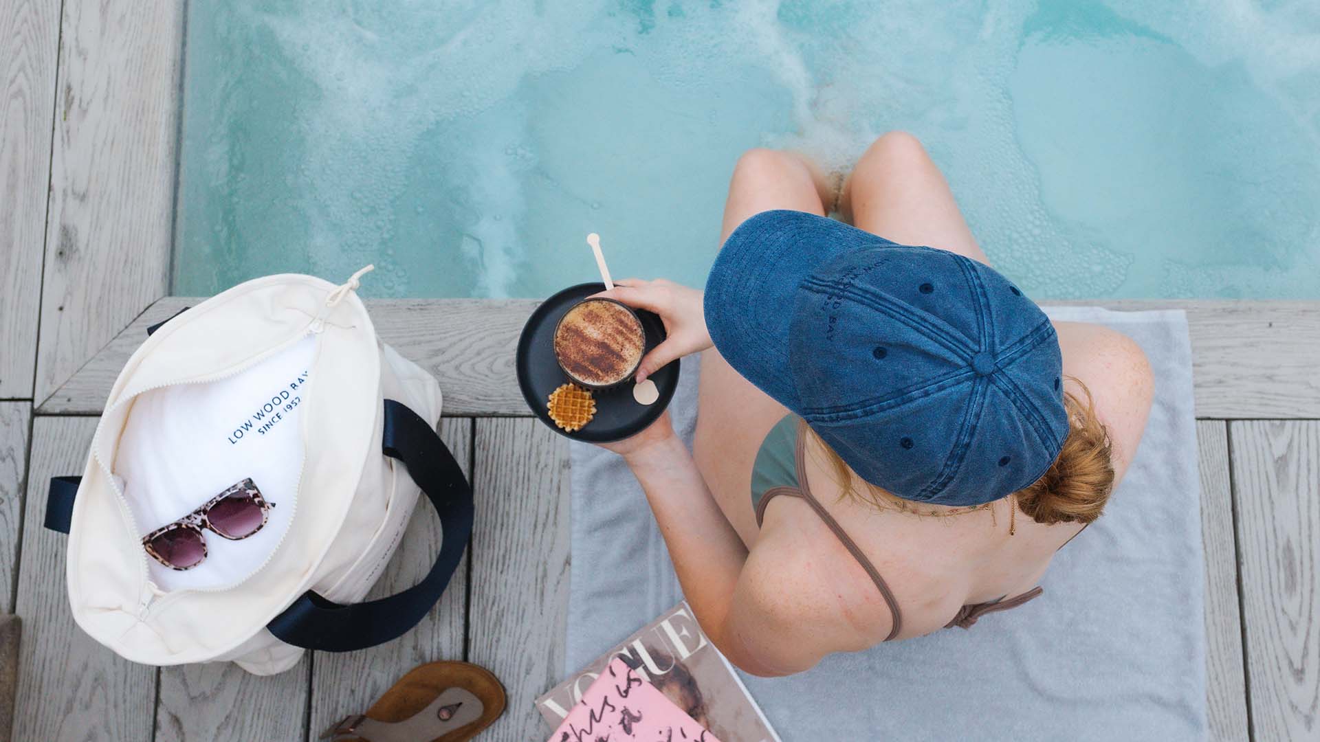 Young woman sat by the poolside